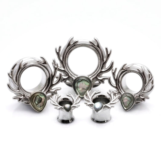 Set of silver deer antler ear tunnels on a white background