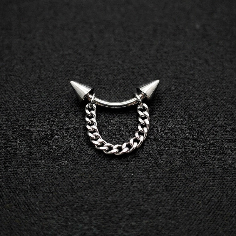 Silver chain ring with spike design on a black background.
